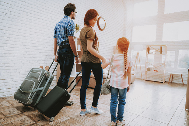 Family with luggage preparing to leave home for a summer vacation.